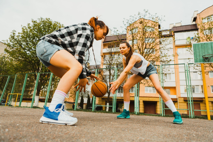 two girls playing basketball outside