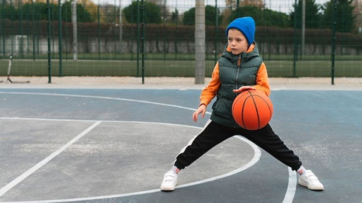 a boy is bouncing a basketball