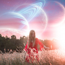 A girl in a field of grass with planets in the sky