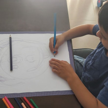 A child works on a self portrait