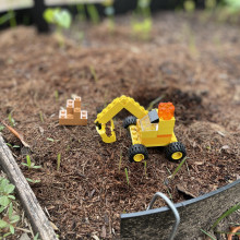 Lego digger playing in a garden