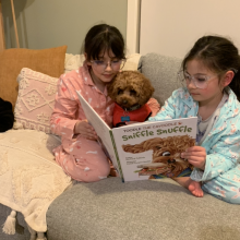 Matilda and Alana reading to Arlo