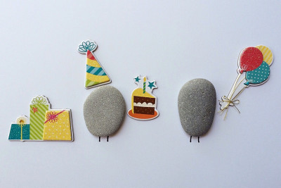 A mixed media image of two pebbles having a birthday party