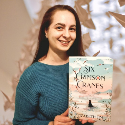 Carrie holds a copy of Six Crimson Cranes