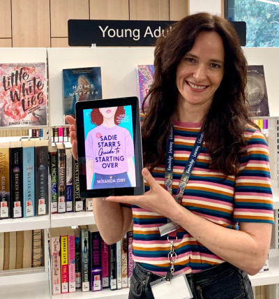 Librarian Jenny holds an ereader with a copy of Sadie Starr's guide to starting over displayed in colour