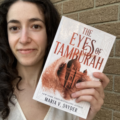 Image of staff member holding the book The Eyes of Tamburah