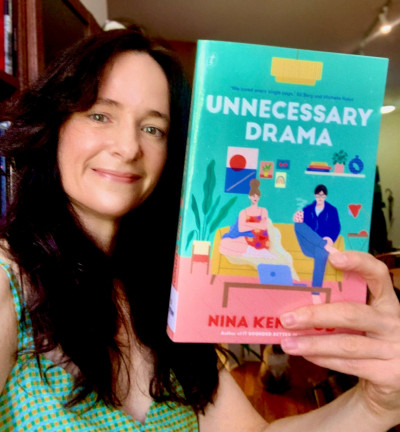 Librarian Jenny holds a copy of Unnecessary Drama