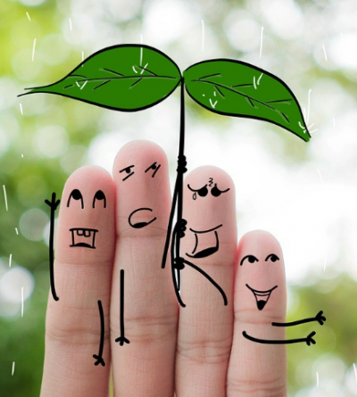 A photograph of 4 fingers with line drawings over to make them a family under an umbrella