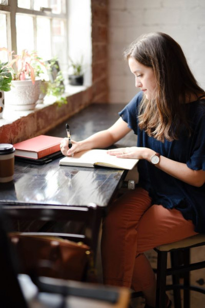 A woman handwriting in front of a window