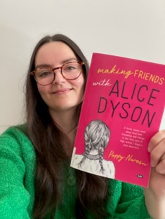 Librarian Anna holds a copy of Making Friends with Alice Dyson, a pink paperback