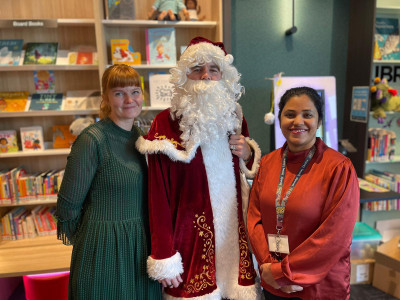 Three library staff, one dressed as Santa, at Williams Landing Library Lounge