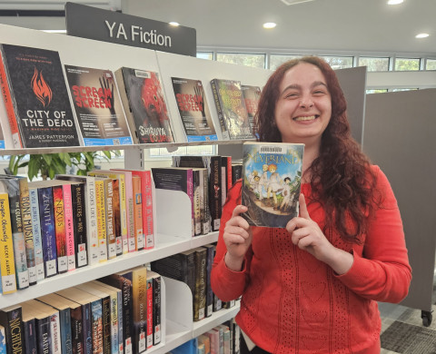 Librarian Carrie holds a copy of The Promised Neverland