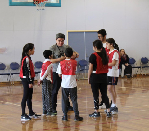 a group of children are listening to their coach
