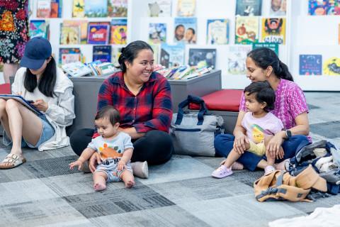 Parents and children sitting together in the library.