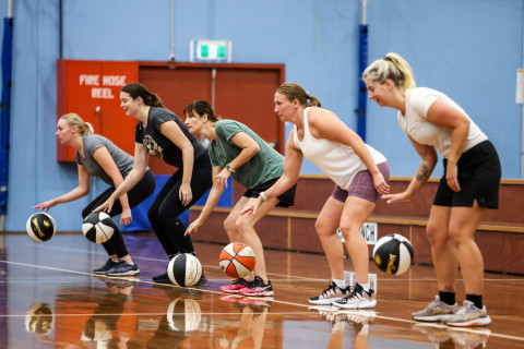 a group of women are bouncing basketballs