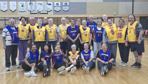 a group of men and women of all ages are smiling at the camera