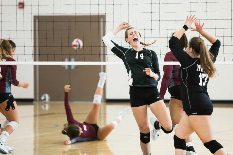 girls in black sports kit are playing volleyball