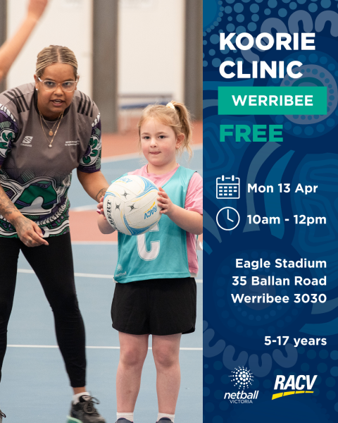 a girl holds a netball whilst a coach is talking to her