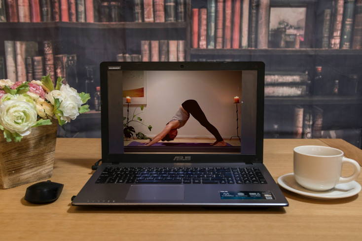 an image of a lady doing a yoga pose shown on a laptop