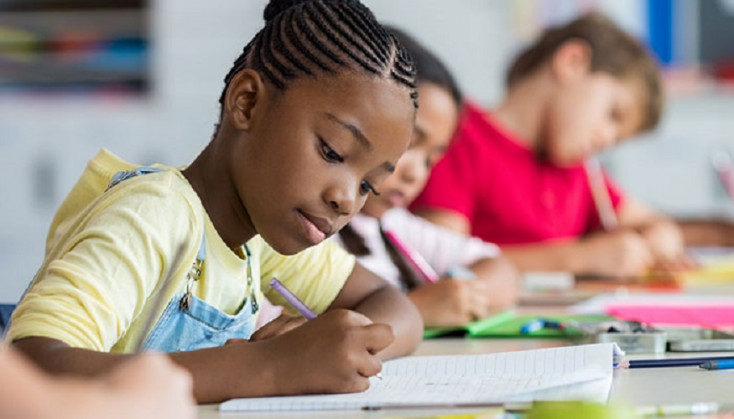 Girl writing in an exercise book.