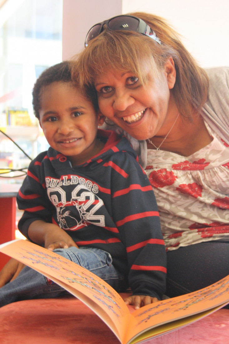 Eva Jo Edwards photographed with a child during one of her Story Time sessions.