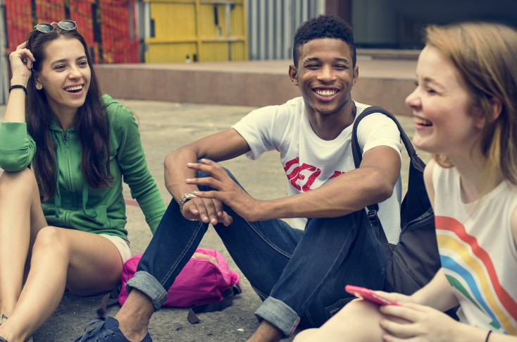 teens sitting down smiling