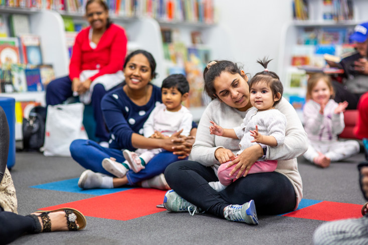 Parents and toddlers sitting on the floor together.