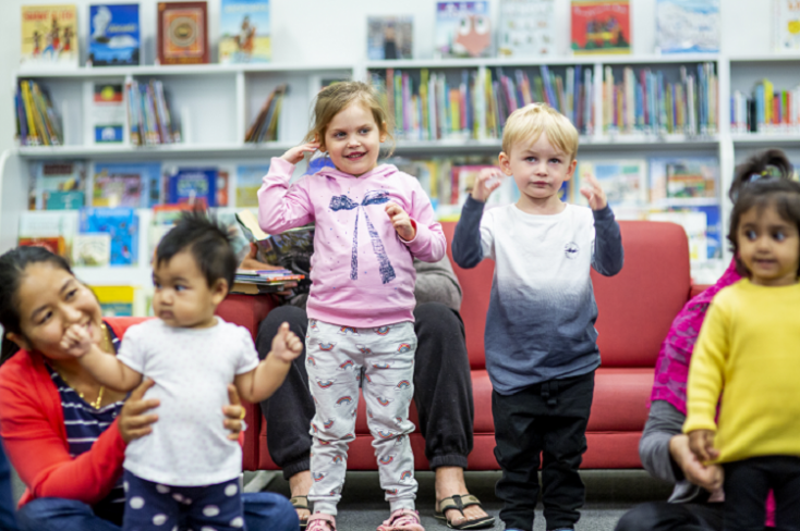 Children and parents dancing in the library.