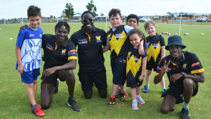 agroup of adults and children wearing black and yellow are smiling at the camera