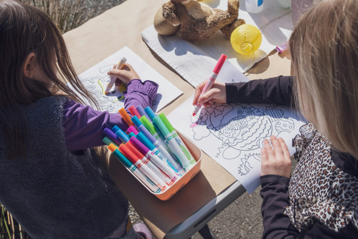 Overhead shot of two children colouring.