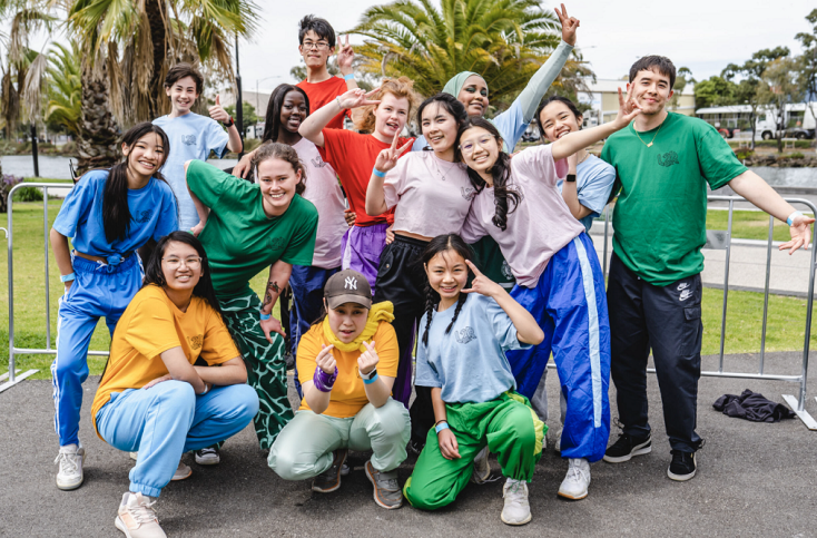 a group of teens are posed in a group and smiling at the camera