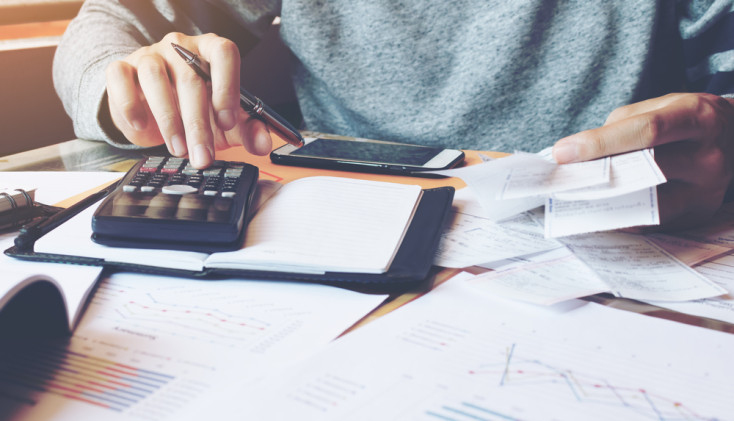 Business desk using calculator and notepad