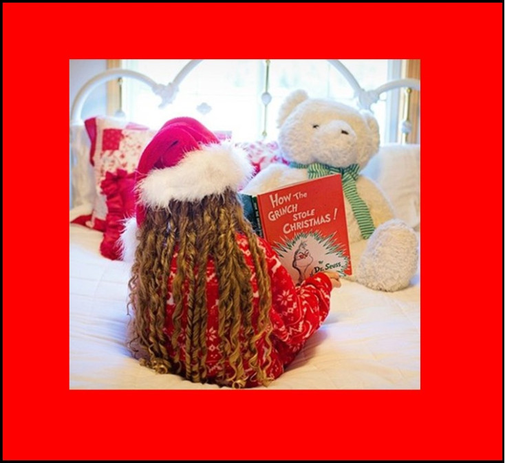 Child reading Christmas book to teddy bear