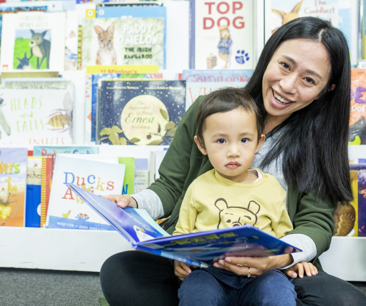Mother reads to child with a picture book