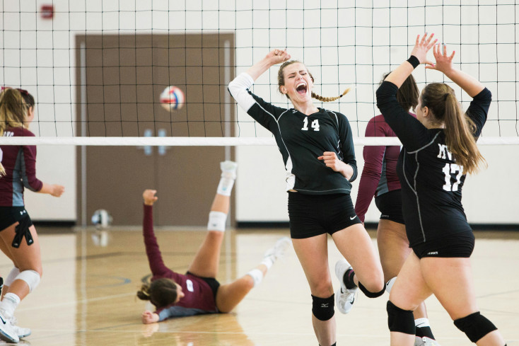 girls in black sports kit are playing volleyball
