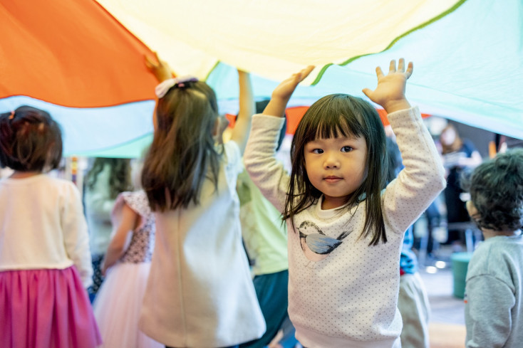 Children at Rhyme Time playing with a parachute