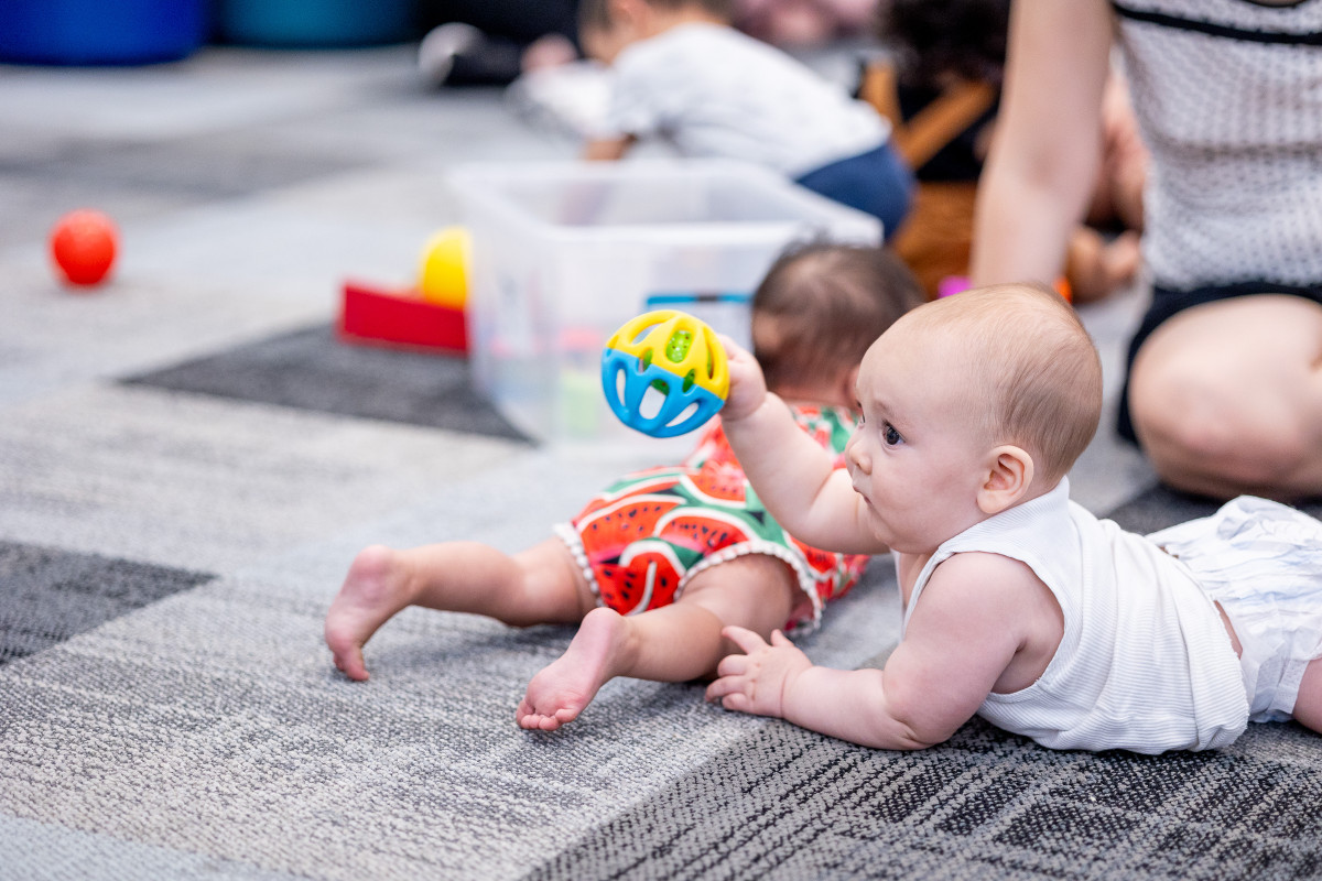 a baby plays with a toy at the library