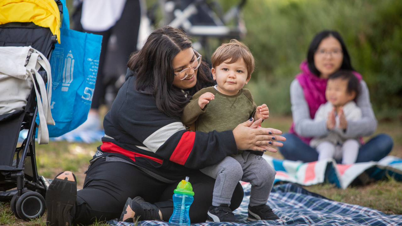 A parent and child at Rhyme Time in the park