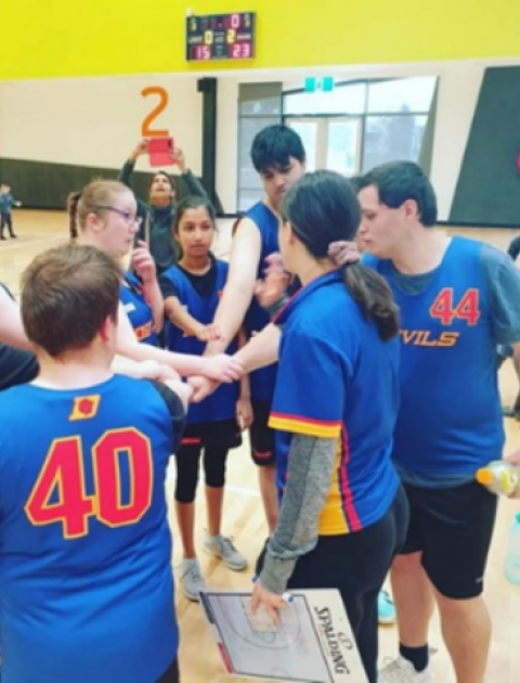 a group of children standing in a circle with their hands reaching into the middle