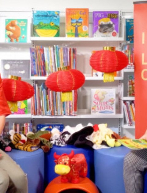 two women wearing red for a Chinese English story time