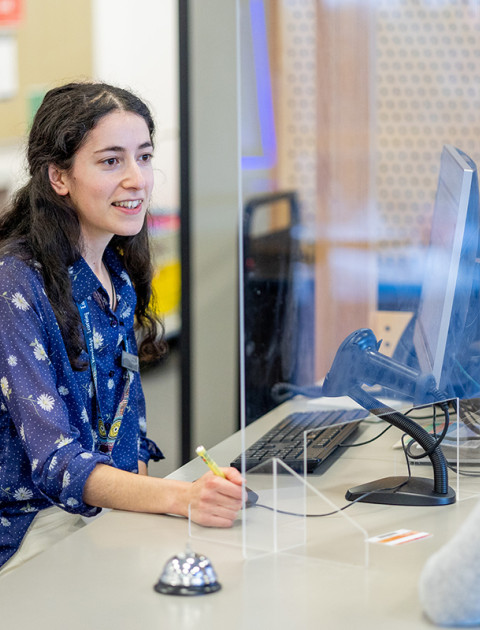 Library customer service staff member helping a patron