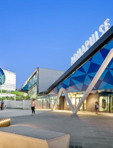a blue building with an enclosed blue slide beside it that twists around 360 degrees 