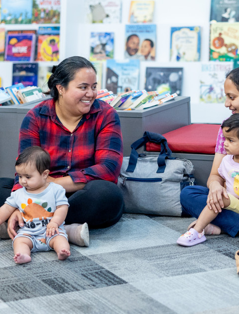 Parents and children sitting together in the library.