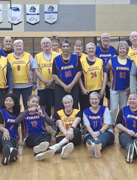 a group of men and women of all ages are smiling at the camera