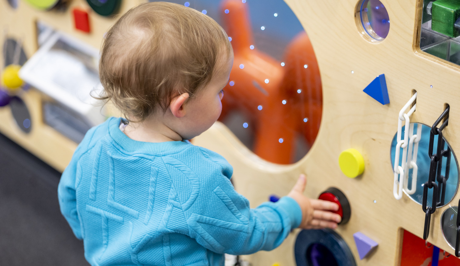 a small child plays with the sensory wall at Tarneit library
