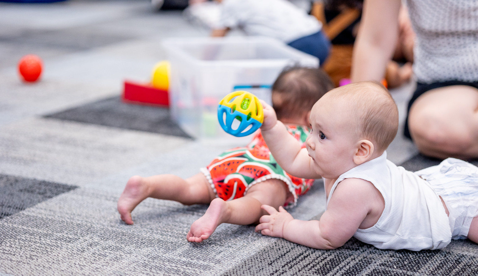 a baby plays with a toy at the library