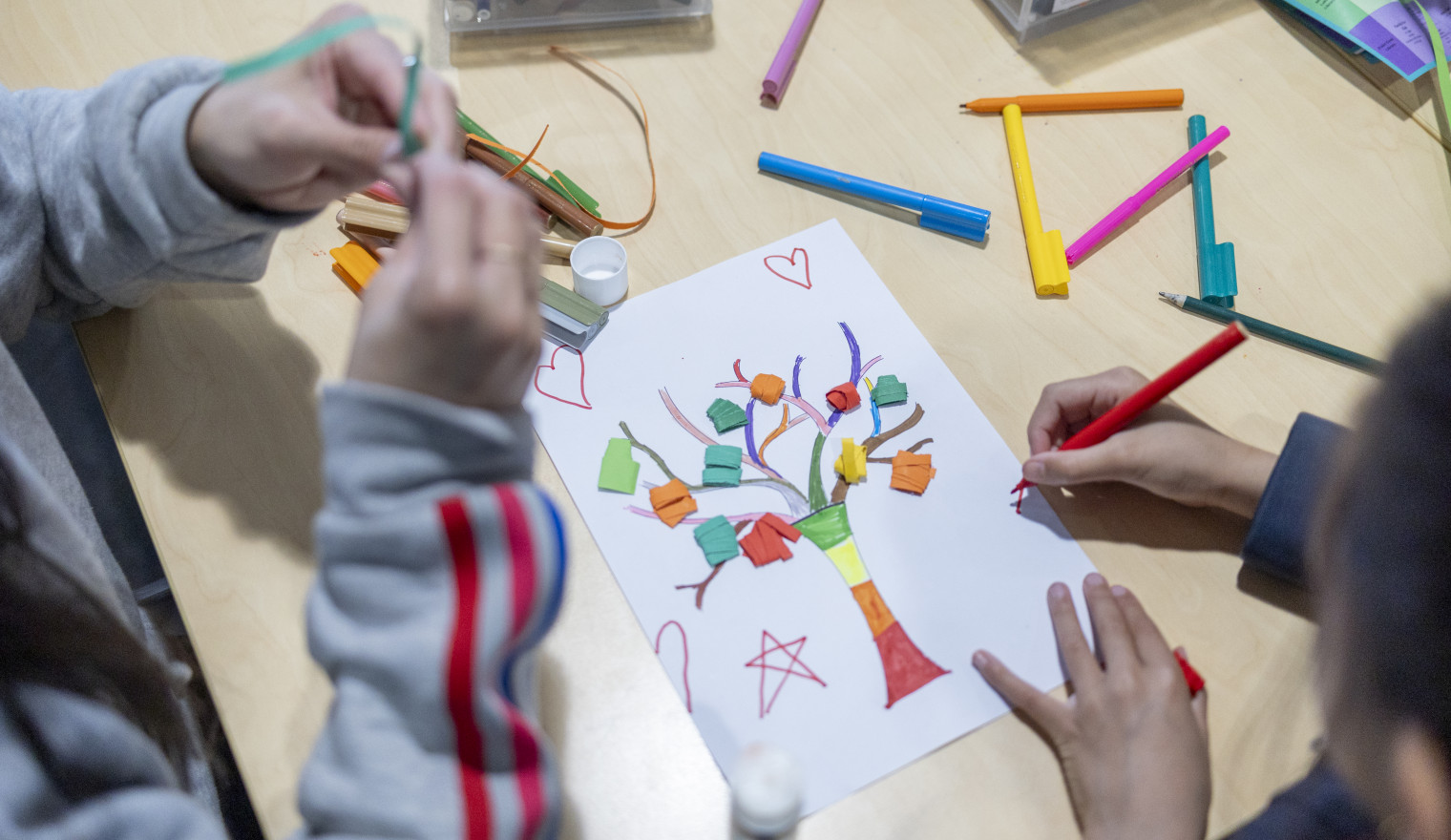 Overhead view of children completing a craft activity at the library.