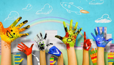 Children's hands painted in various colours, raised in front of a cartoon landscape.