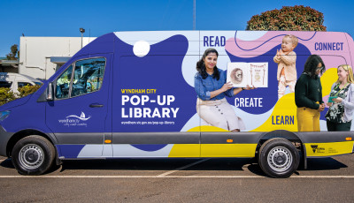 The library programs van is painted with people reading and laughing, and the text "Pop-up Library"