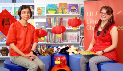 two women wearing red for a Chinese English story time